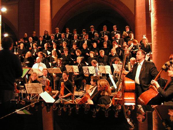 Chor der Heidelberger Studentenkantorei mit Orchester im Vordergrund.